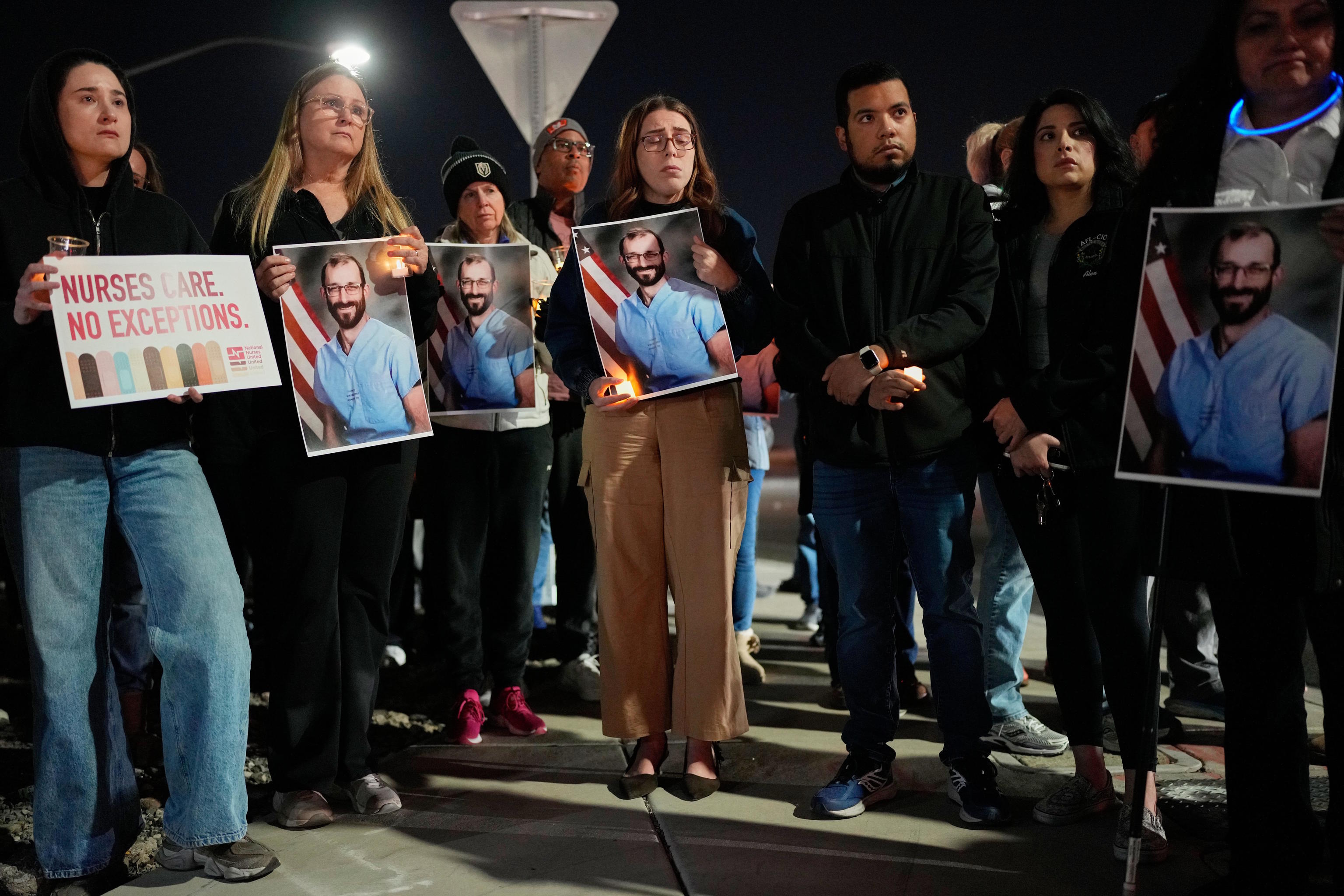 Several people participate in a vigil in honor of nurse Alex Pretti.