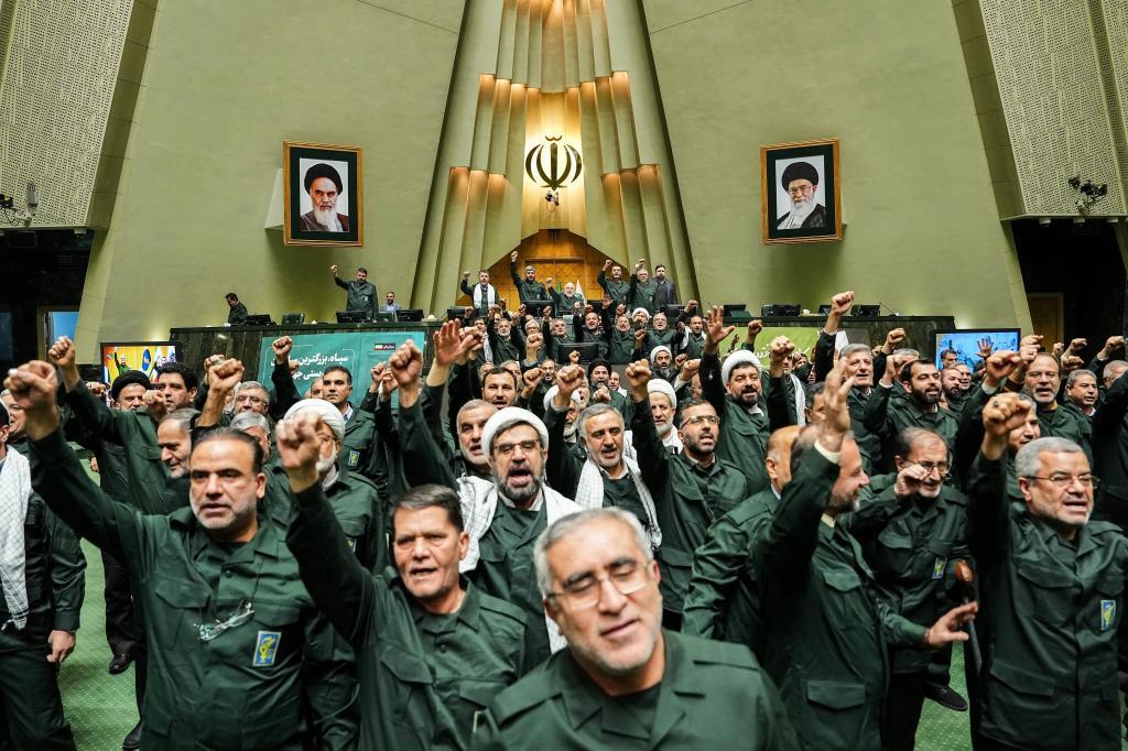 Iranian lawmakers chant slogans as they wear the Revolutionary Guard's uniform