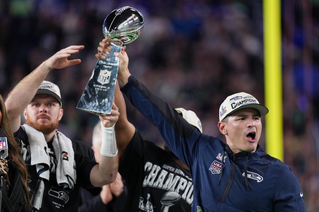 Seattle Seahawks head coach Mike Macdonald, right, and quarterback Sam Darnold lift the Lombardi Trophy after a win over the New England Patriots in the NFL Super Bowl