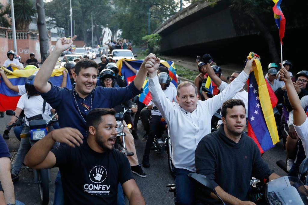 Opposition leader Juan Pablo Guanipa, right, and political activist Jesus Armas ride on the back of motorbikes after their release from prison in Caracas