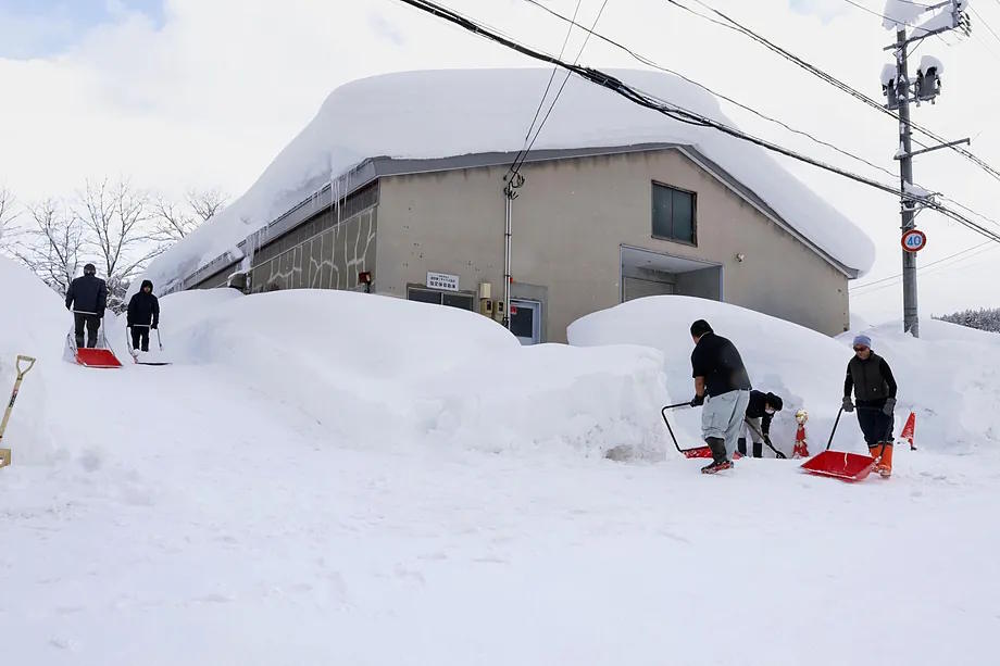 People clearing snow near a building in Aomori, northern Japan.