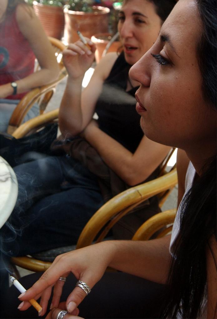 Some young people smoking cigarretes.