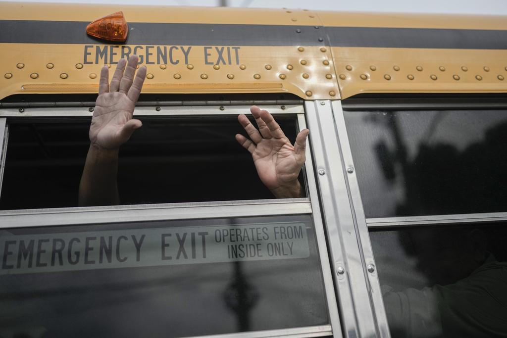 Nicaraguan citizens wave from a bus.