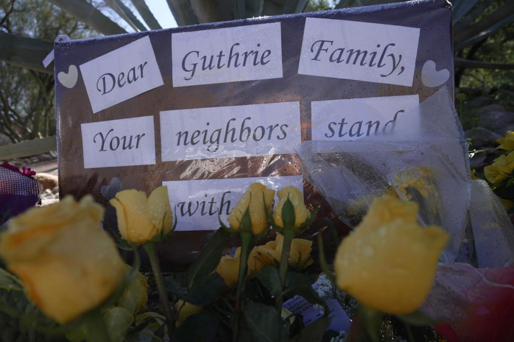 Yellow flowers and signs remain at a vigil outside of Nancy Guthrie's home