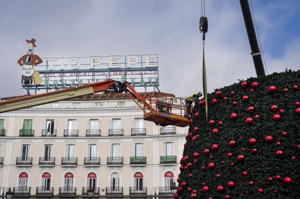 A worker takes down a giant Christmas tree from Puerta del Sol square in downtown Madrid