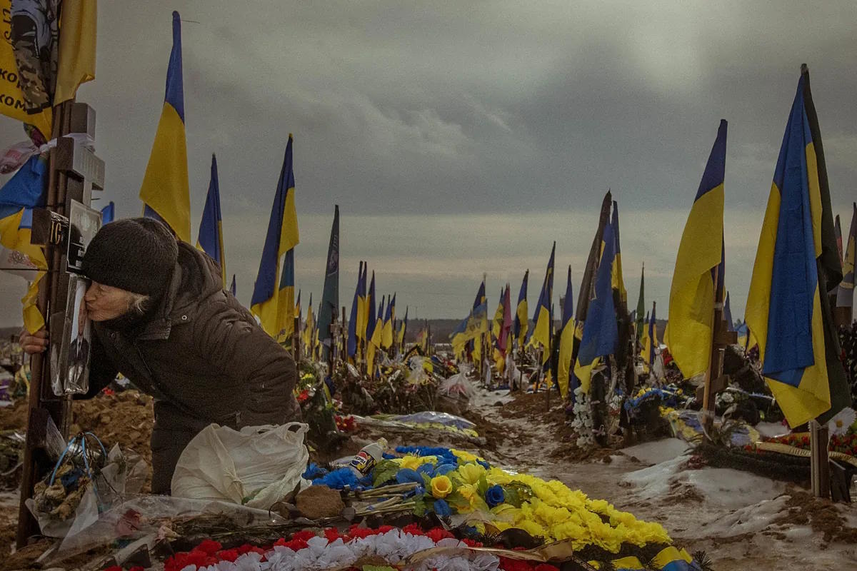 Vita, 82, kisses her son's portrait at the J�rkiv cemetery.
