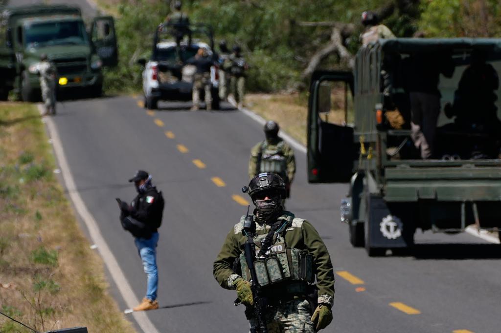 A soldier clears a roadblock on a road leading to Tapalpa