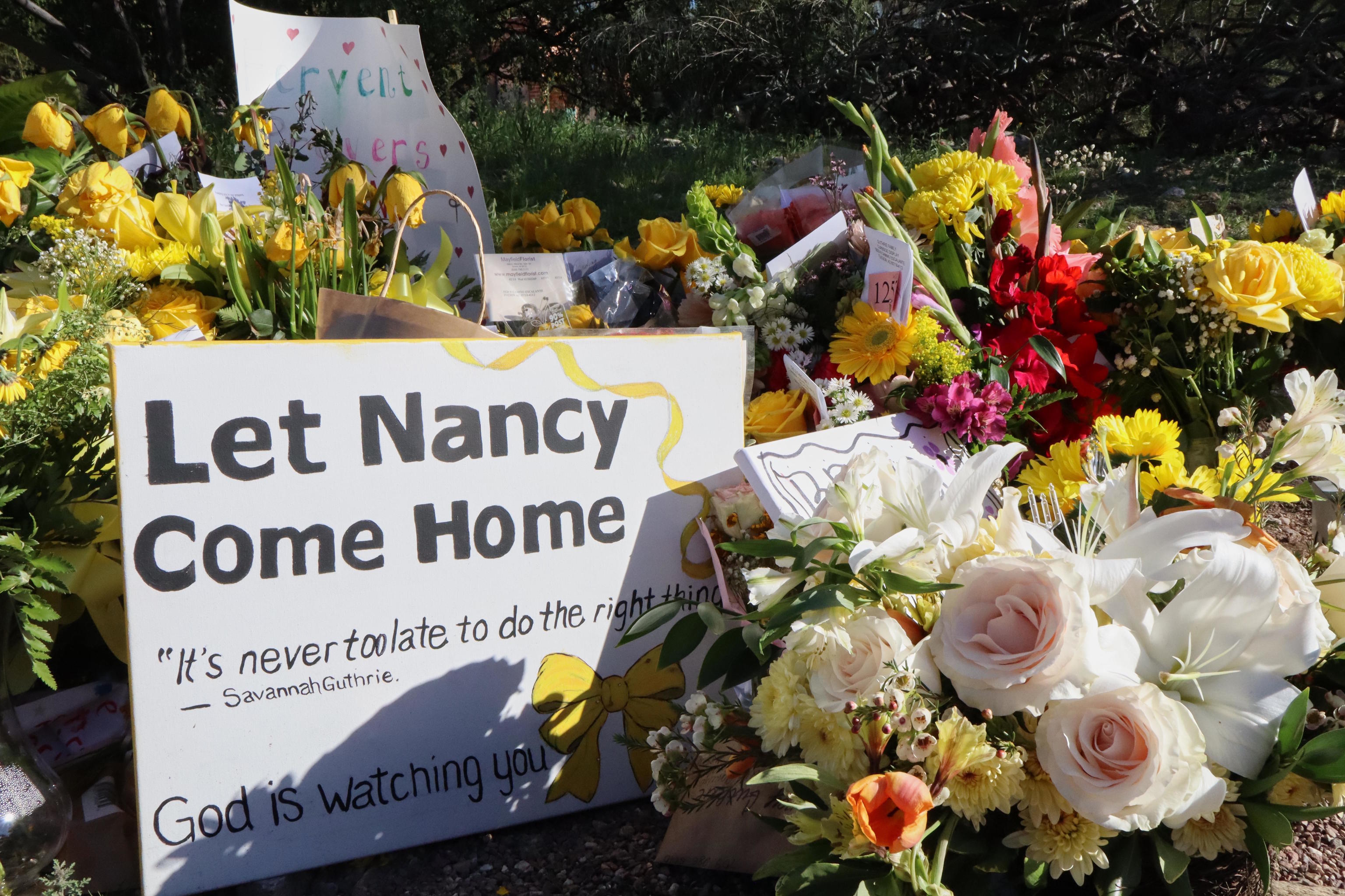 A memorial grows outside the home of Nancy Guthrie.