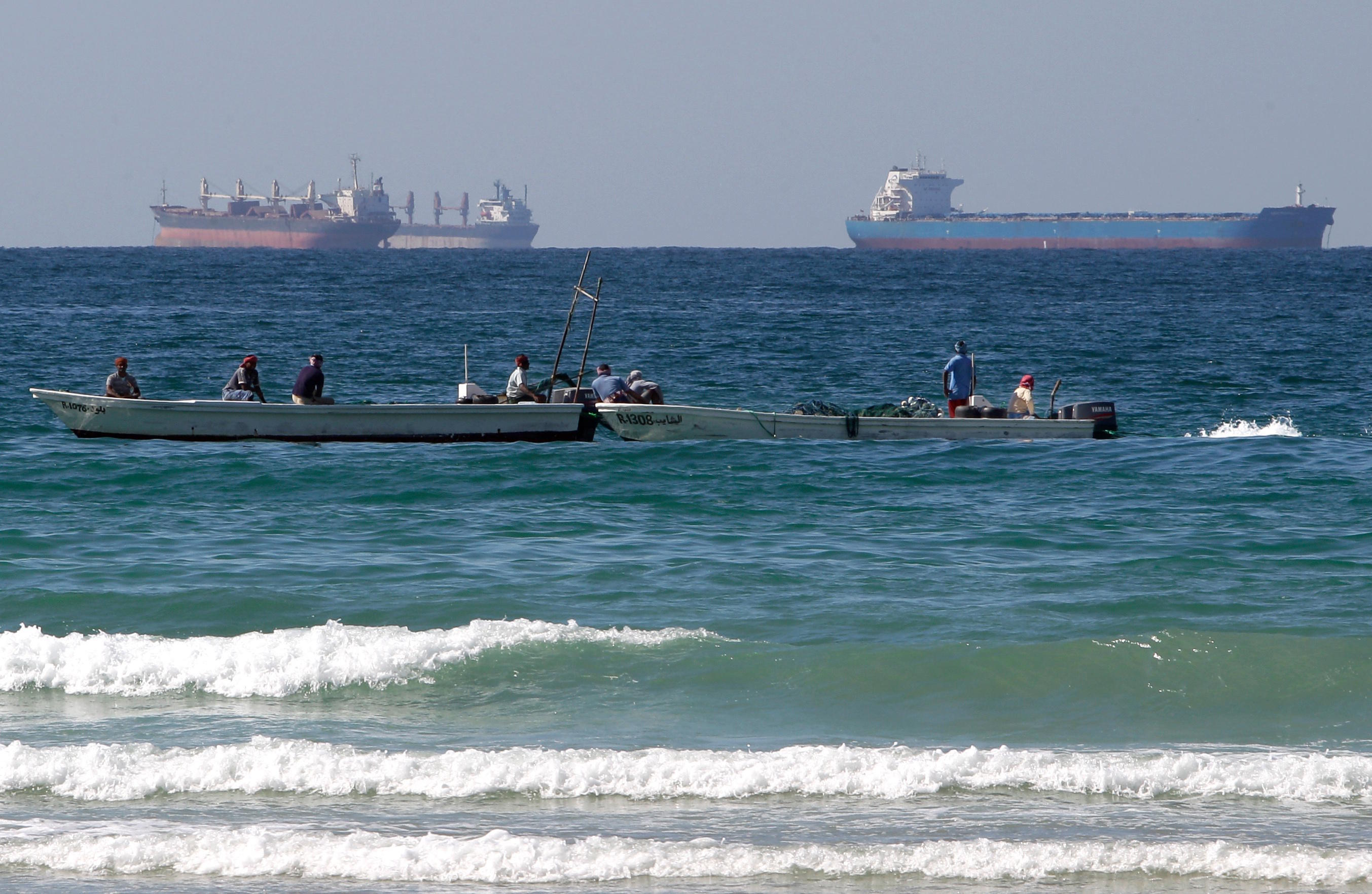 File photo of fishermen in front of tankers south of the Strait of Hormuz.
