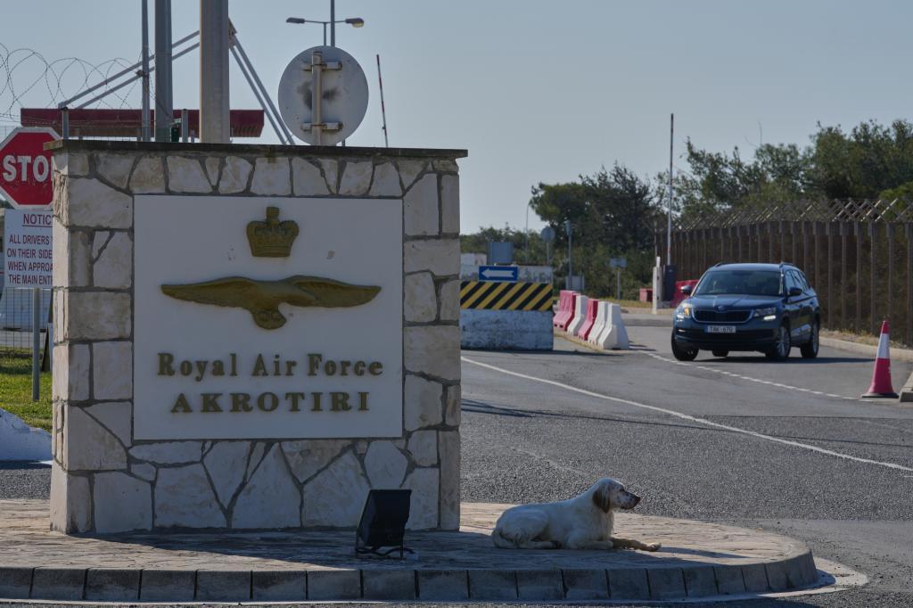 Cars with employees leave the main gate of the U.K.'s RAF Akrotiri air base