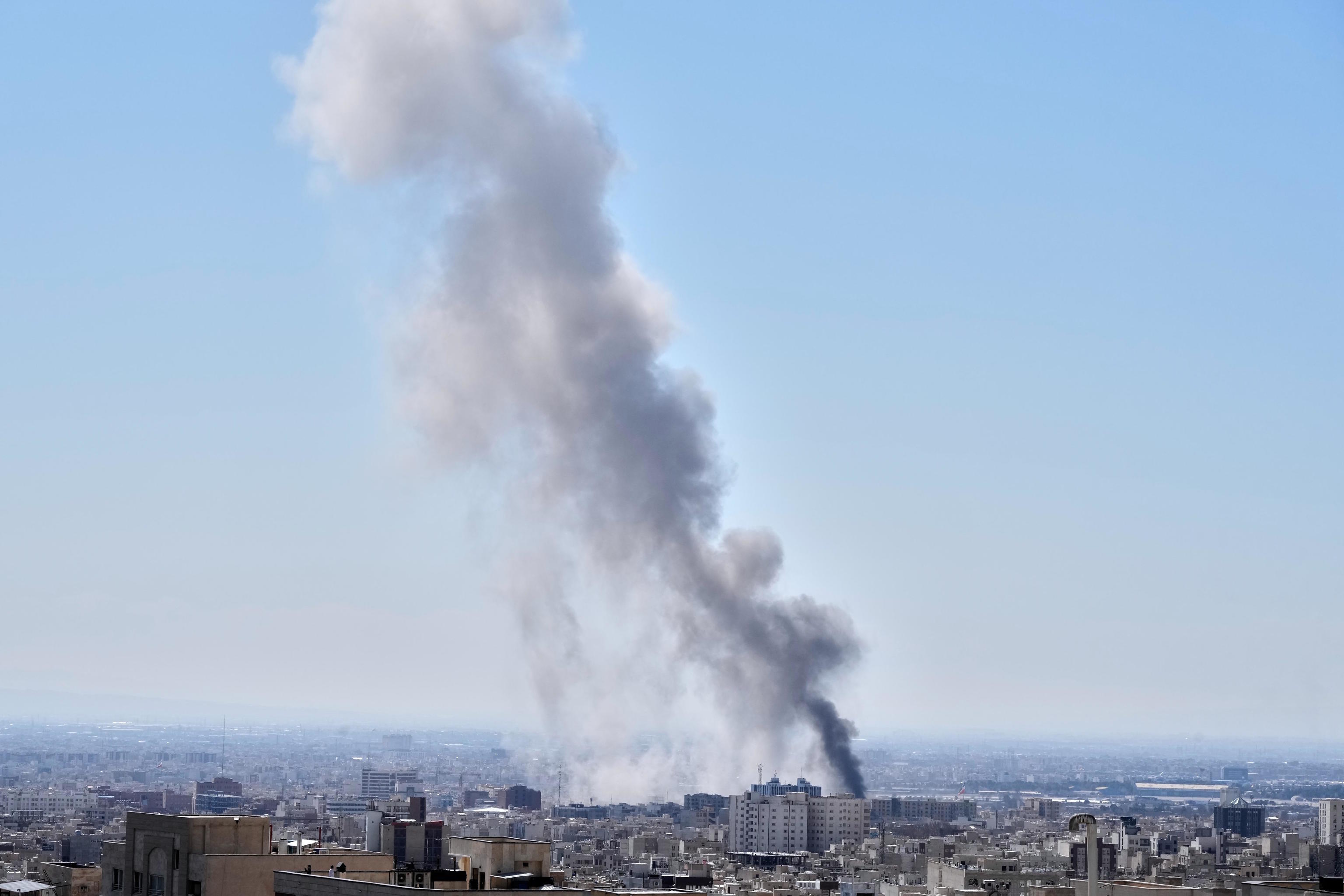 A column of smoke rises after an attack in Tehran.