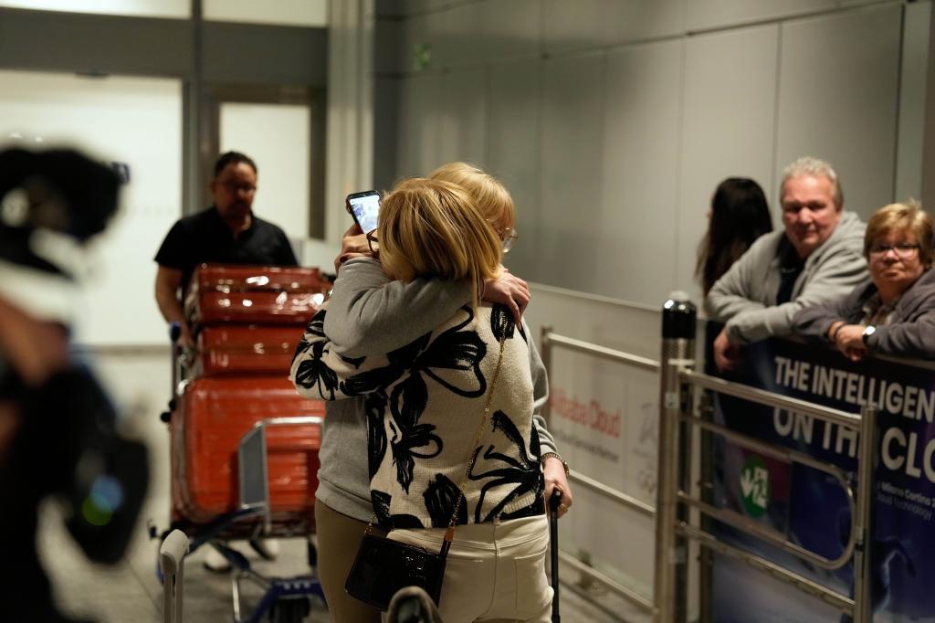 People arrive at the International Airport in Frankfurt, Germany, after being evacuated from Dubai on a commercial flight