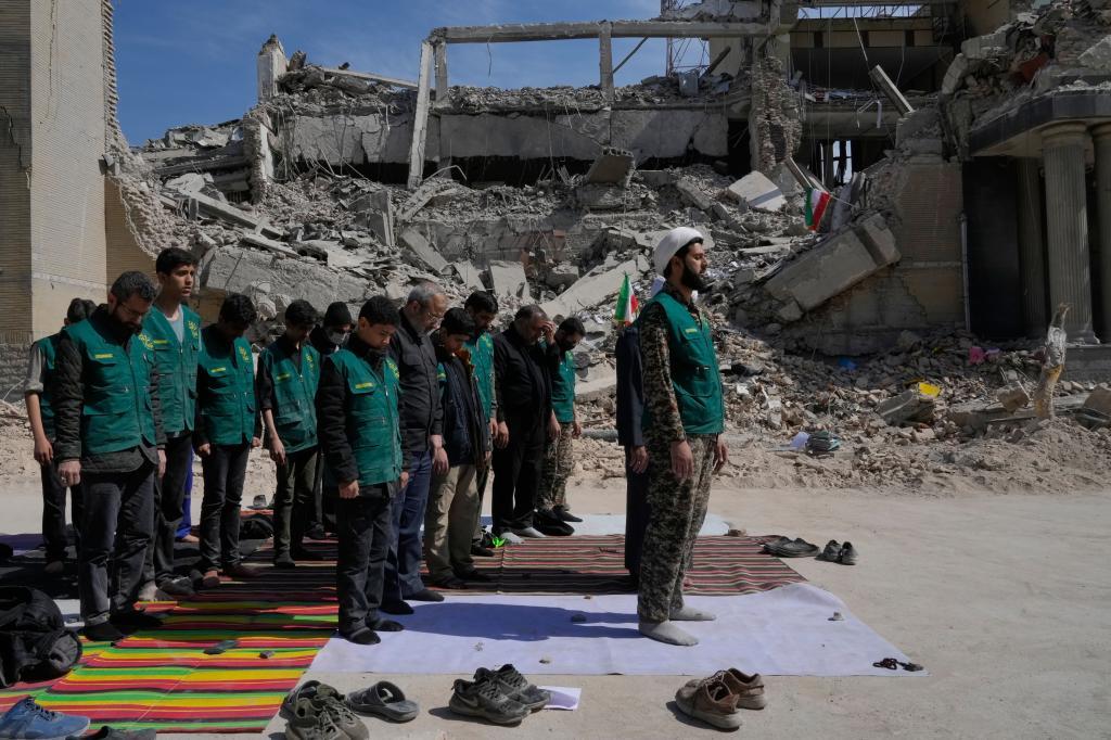 A cleric leads a group of volunteers in prayer.