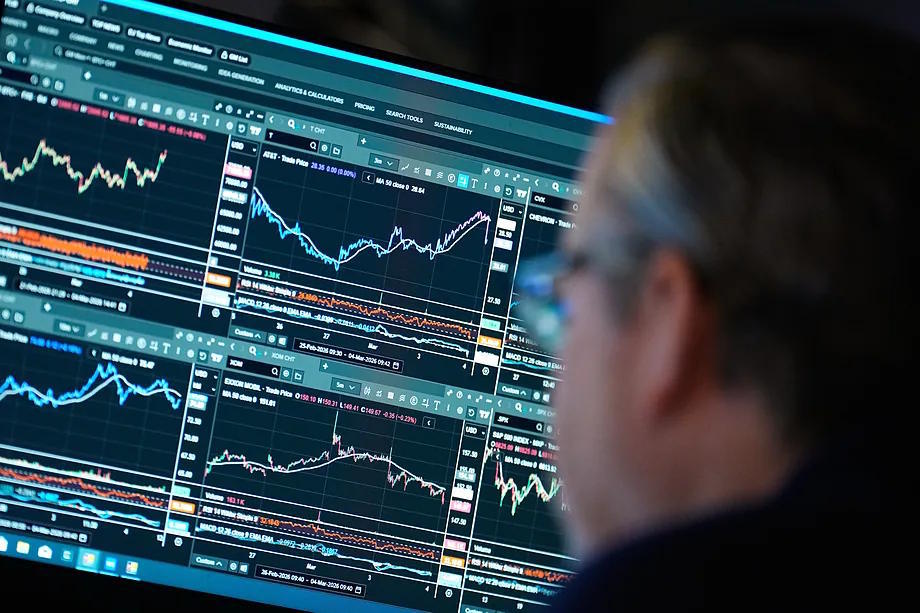 A trader watches financial information on a screen.