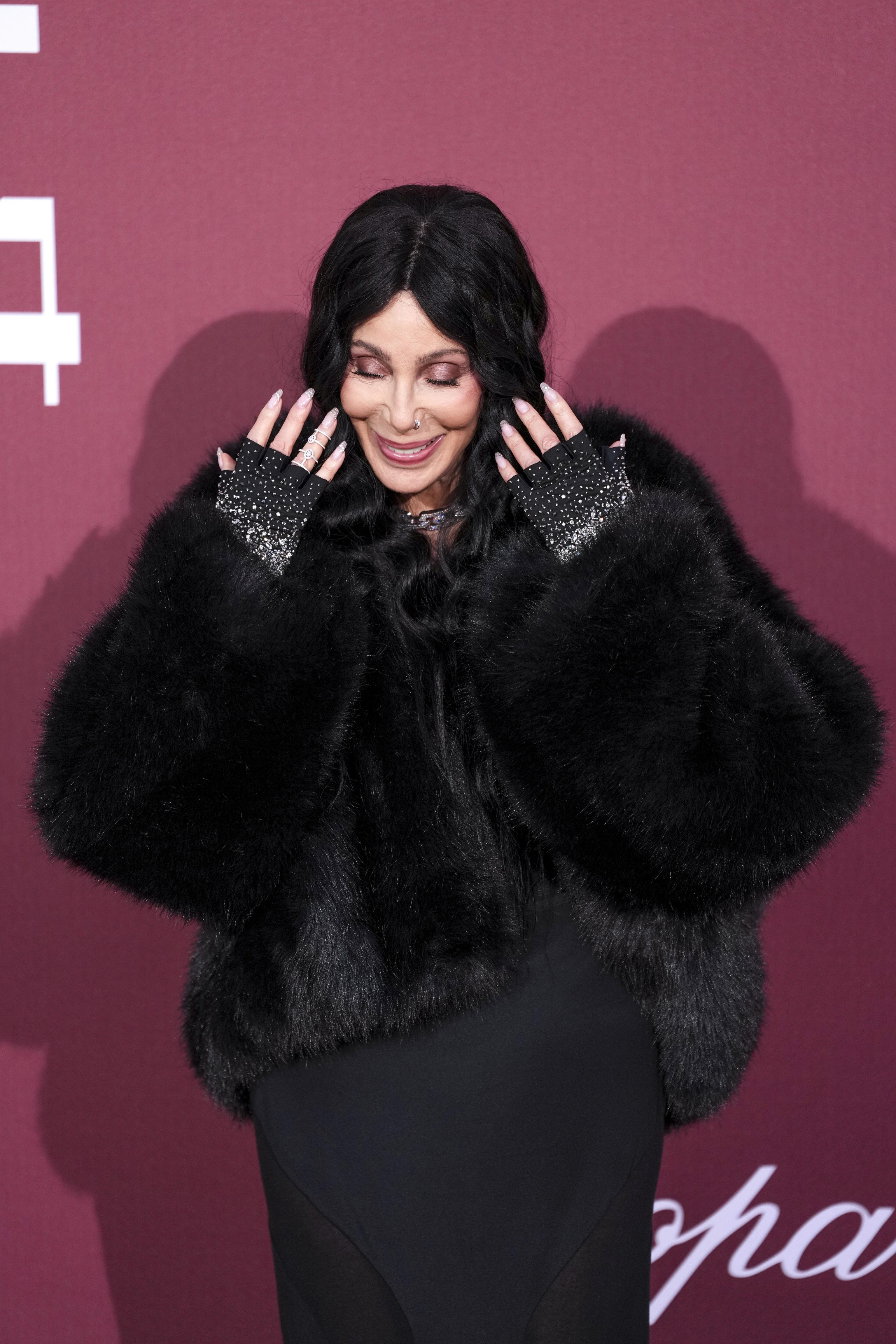 Cher poses for photographers in 2025.