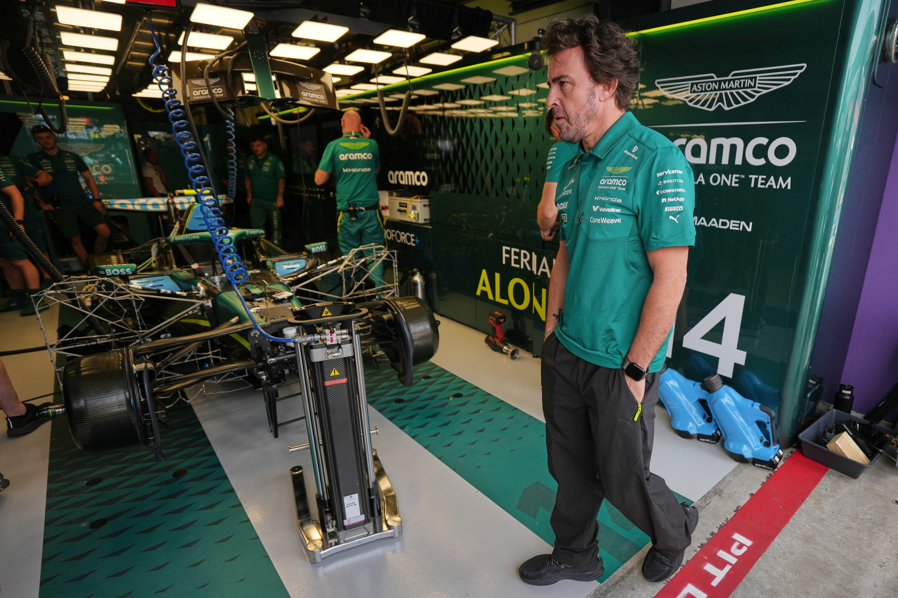 Aston Martin driver Fernando Alonso of Spain waits in his team garage.