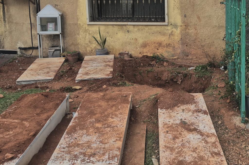 A grave, background, dug by Israeli forces landed overnight late Friday, searching for Israeli co-pilot Ron Arad