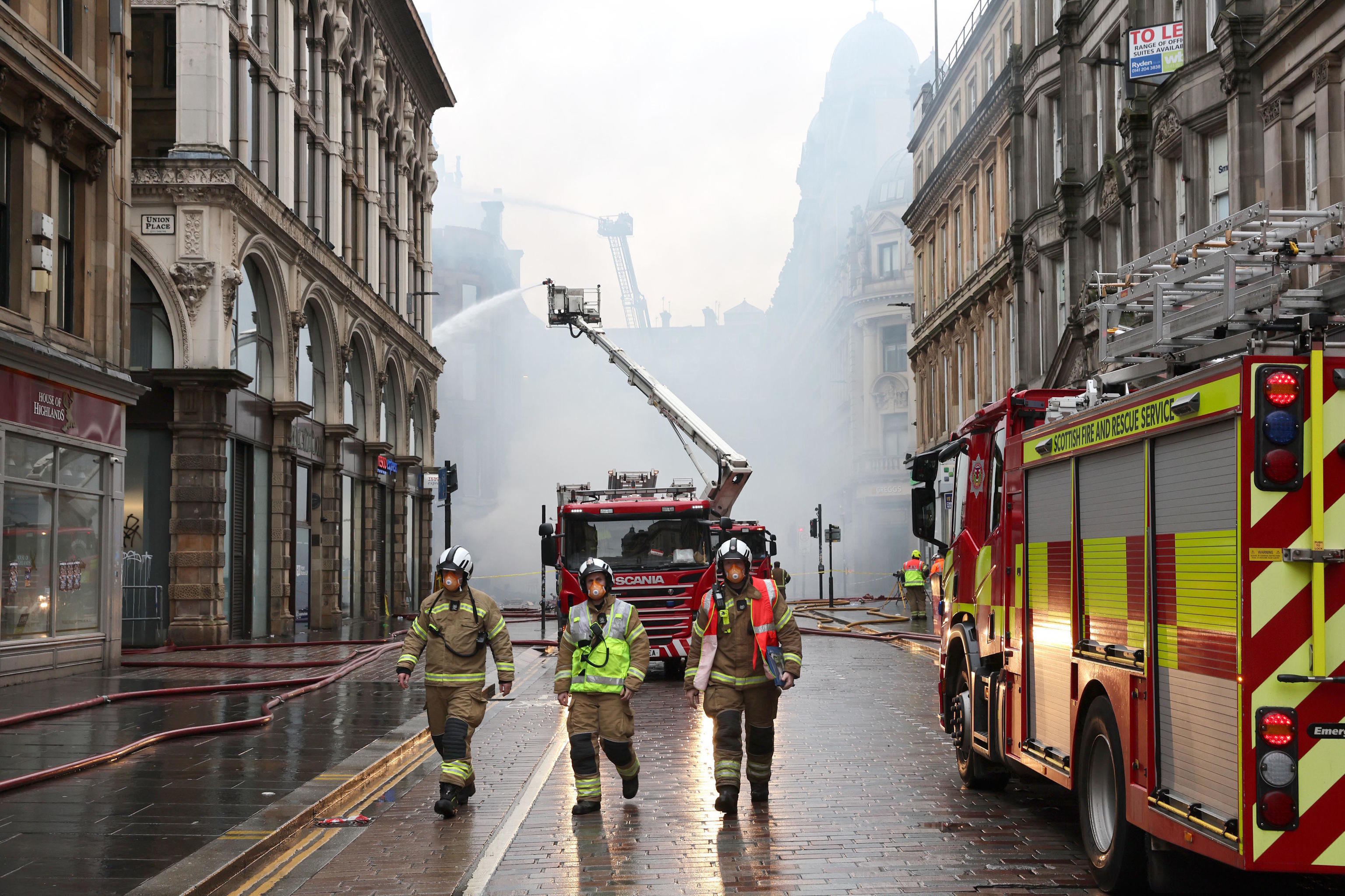 Firefighters soak the remains of a fire in a building next to Glasgow Central Station.
