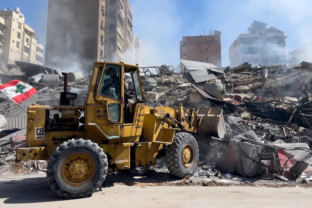 A bulldozer removes the wreckage of a destroyed building that was hit by an Israeli airstrike in Dahiyeh