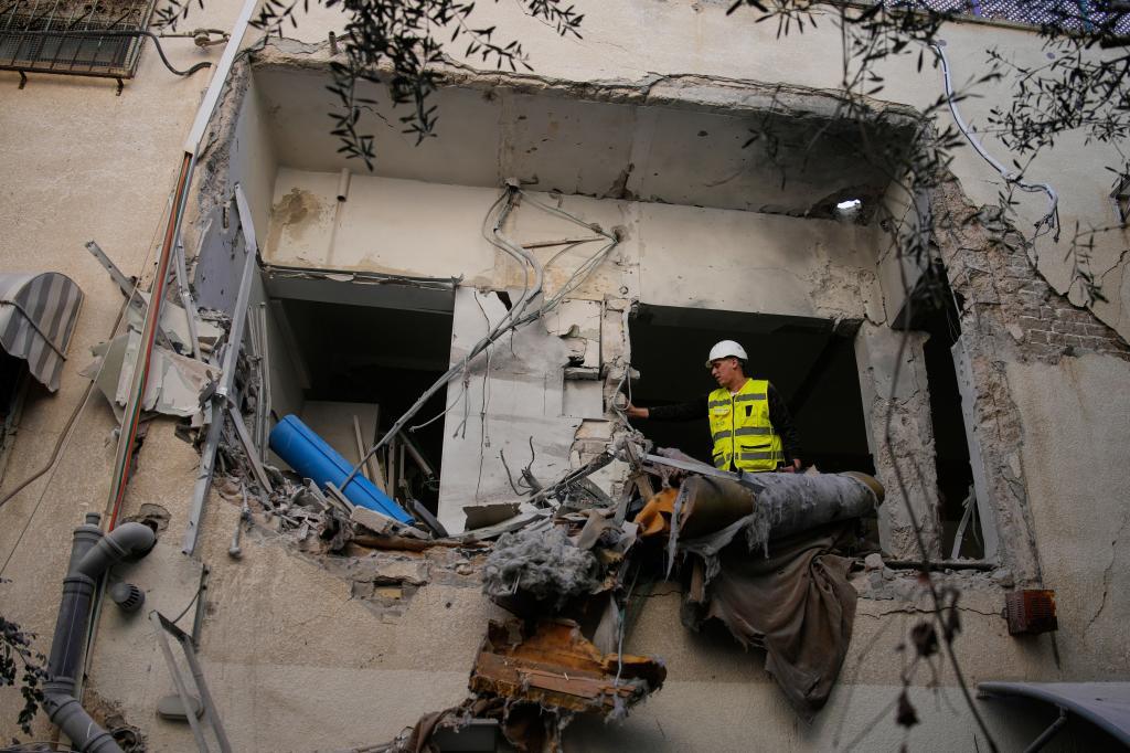 Israeli security forces inspect a damaged apartment building struck by an Iranian missile in Tel Aviv,