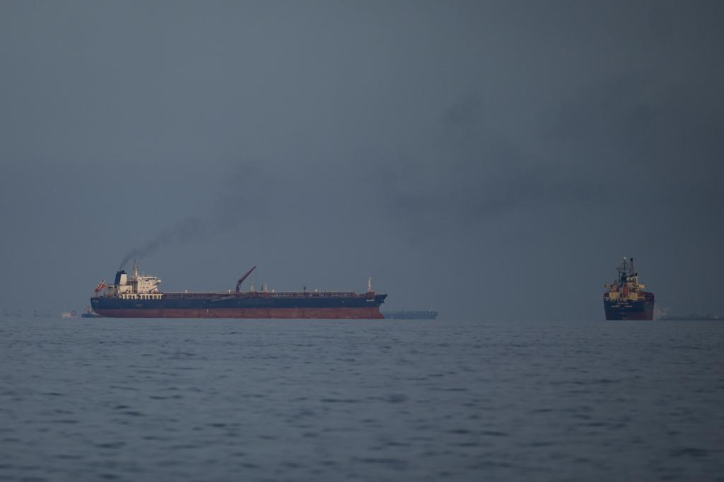 Oil tankers and cargo ships line up in the Strait of Hormuz as seen from Khor Fakkan