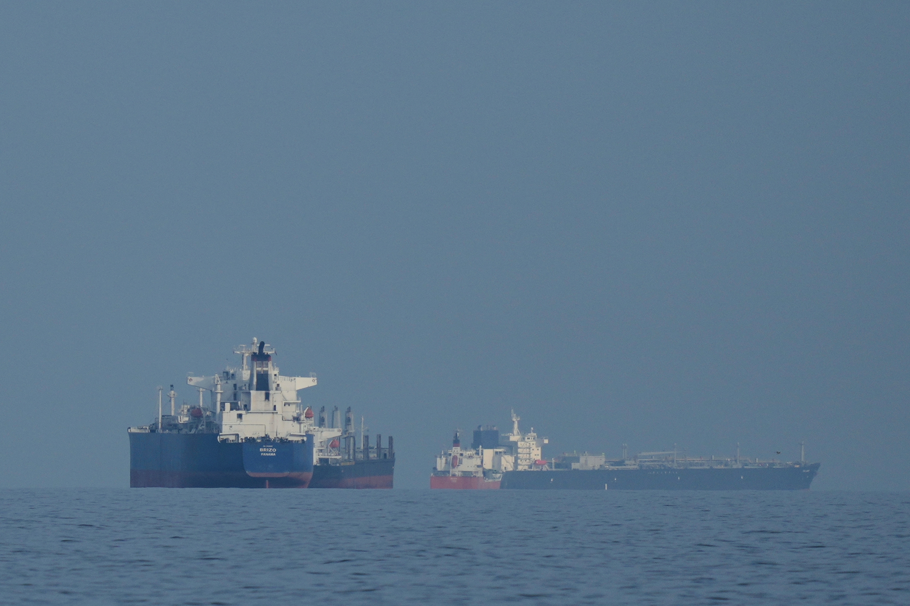 Oil tankers and cargo ships line up in the Strait of Hormuz as seen from Khor Fakkan, United Arab Emirates.