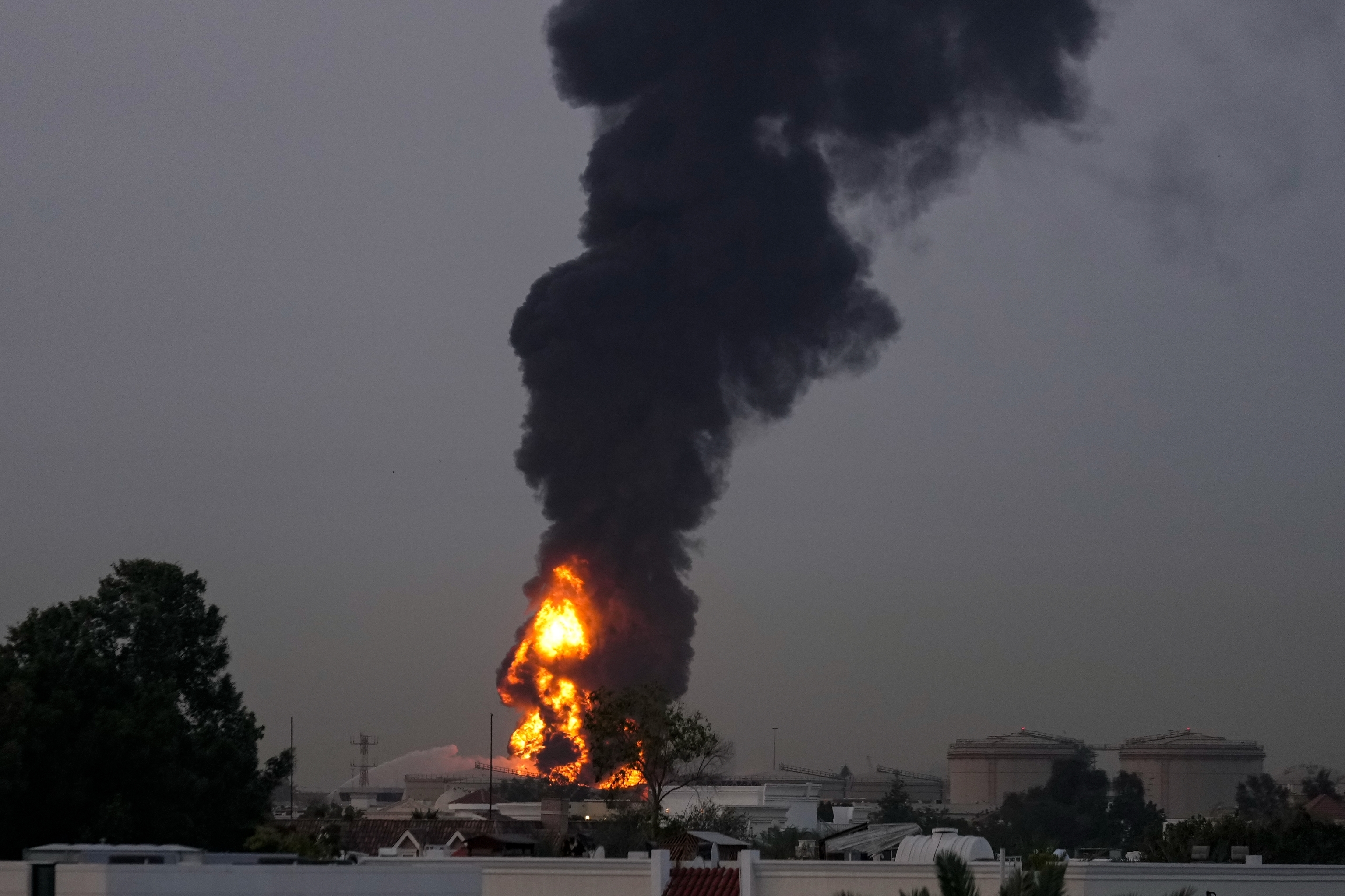 Fire and plumes of smoke rises after a drone struck a fuel tank forcing the temporary suspension of flights.