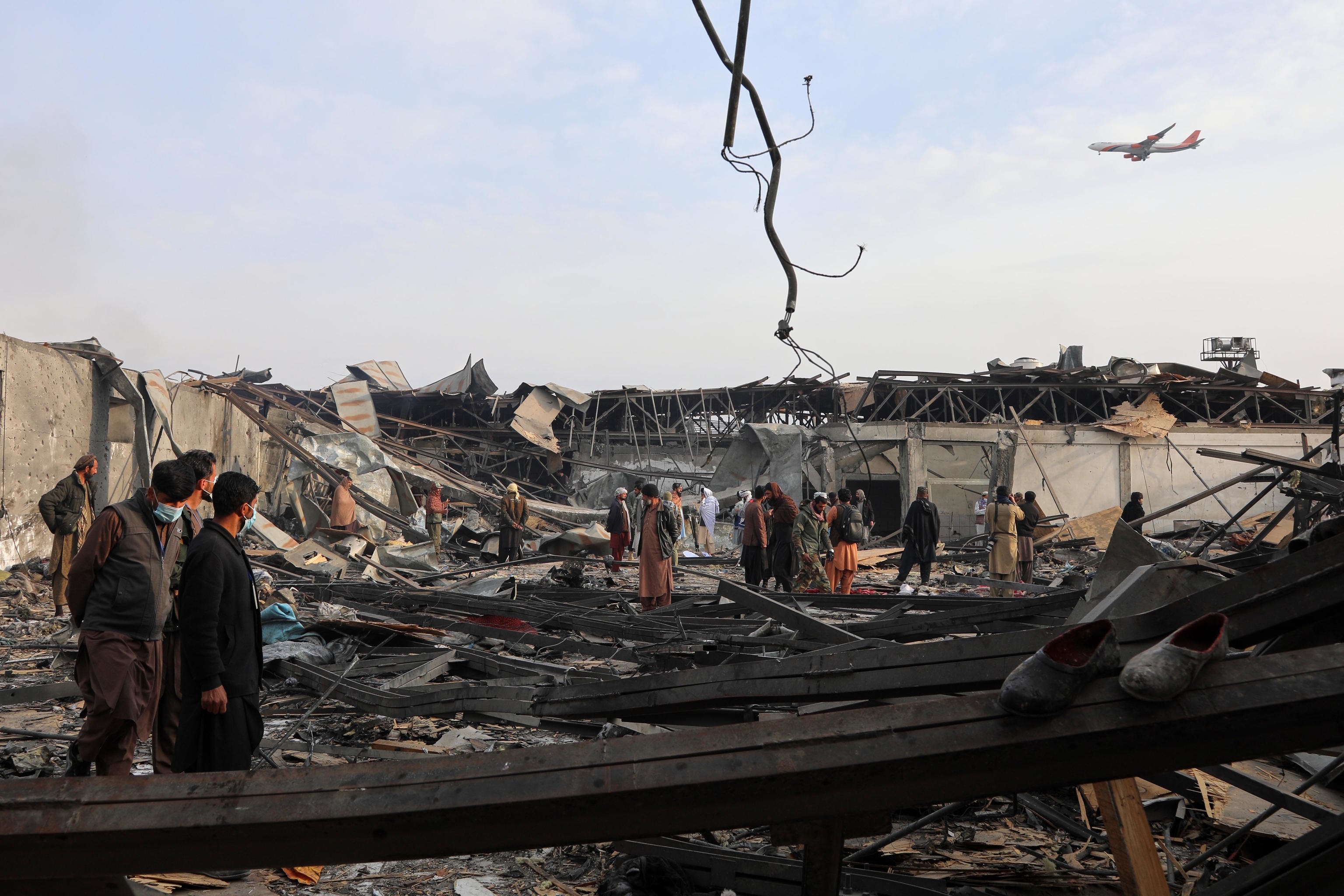Residents and volunteers inspect the site of an airstrike on a drug rehabilitation hospital in Kabul.