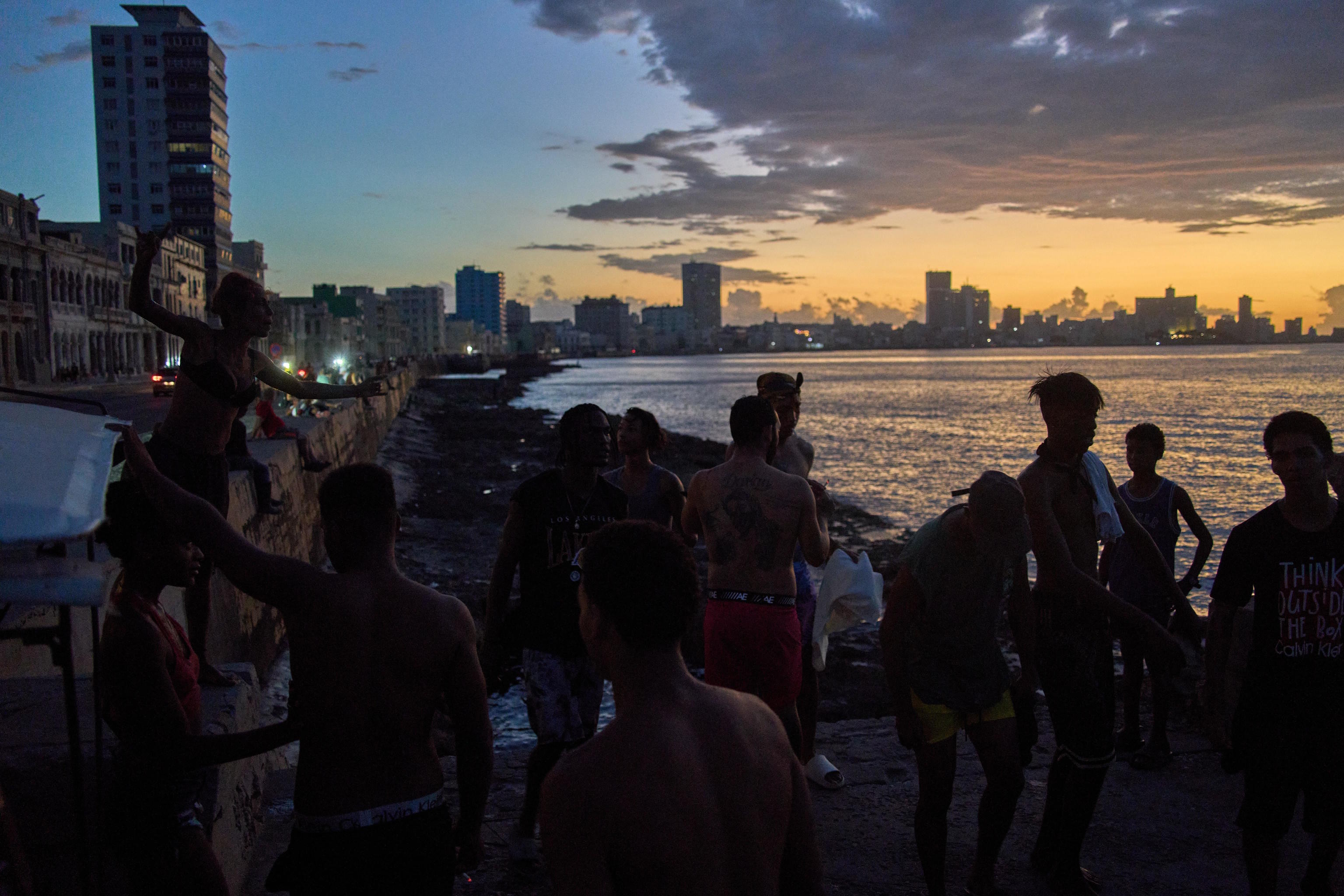 People watch the sunset from the Malec�n during a blackout in Havana.