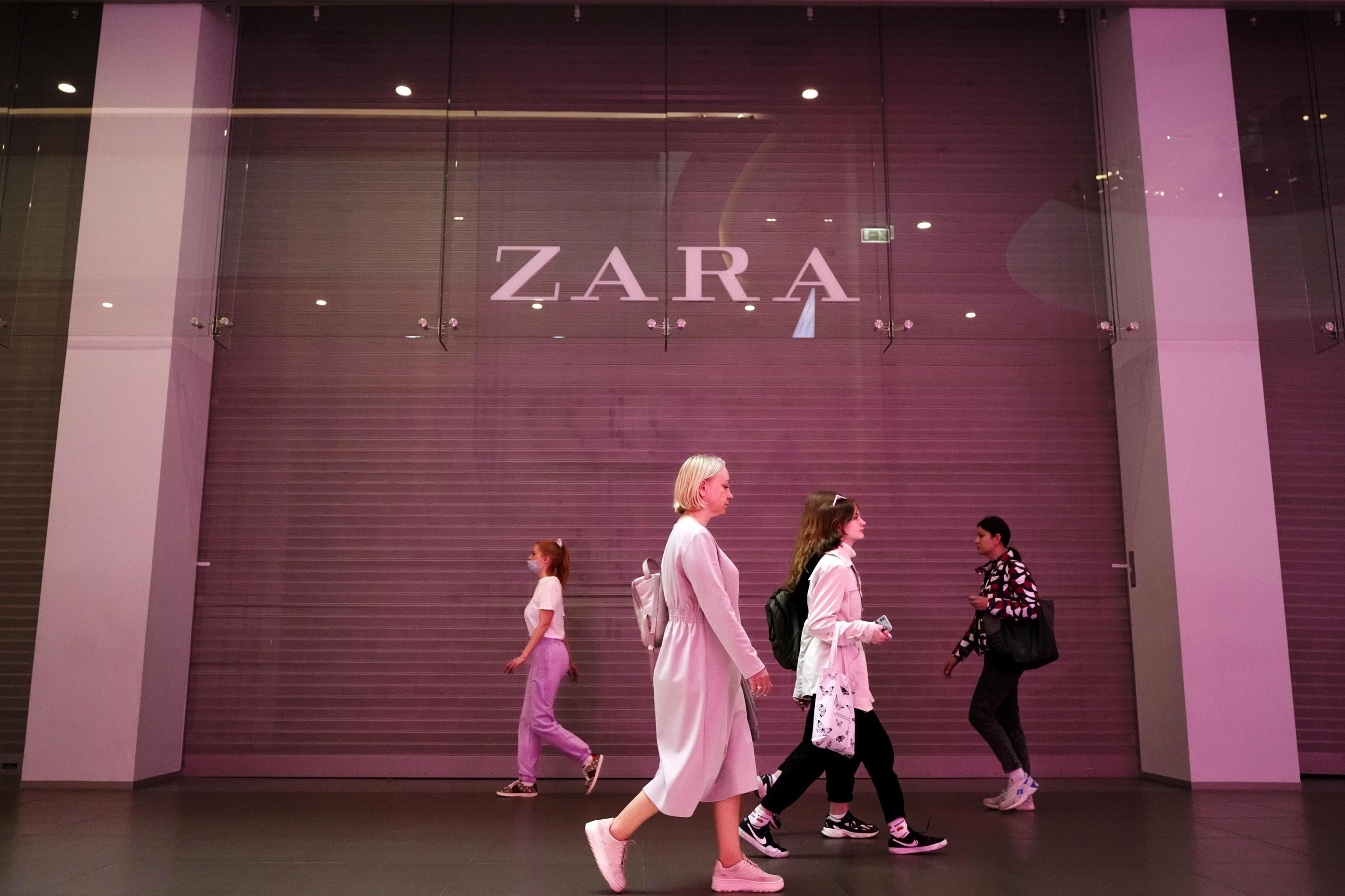 People walk past a Zara shop closed in a shopping mall in St. Petersburg,