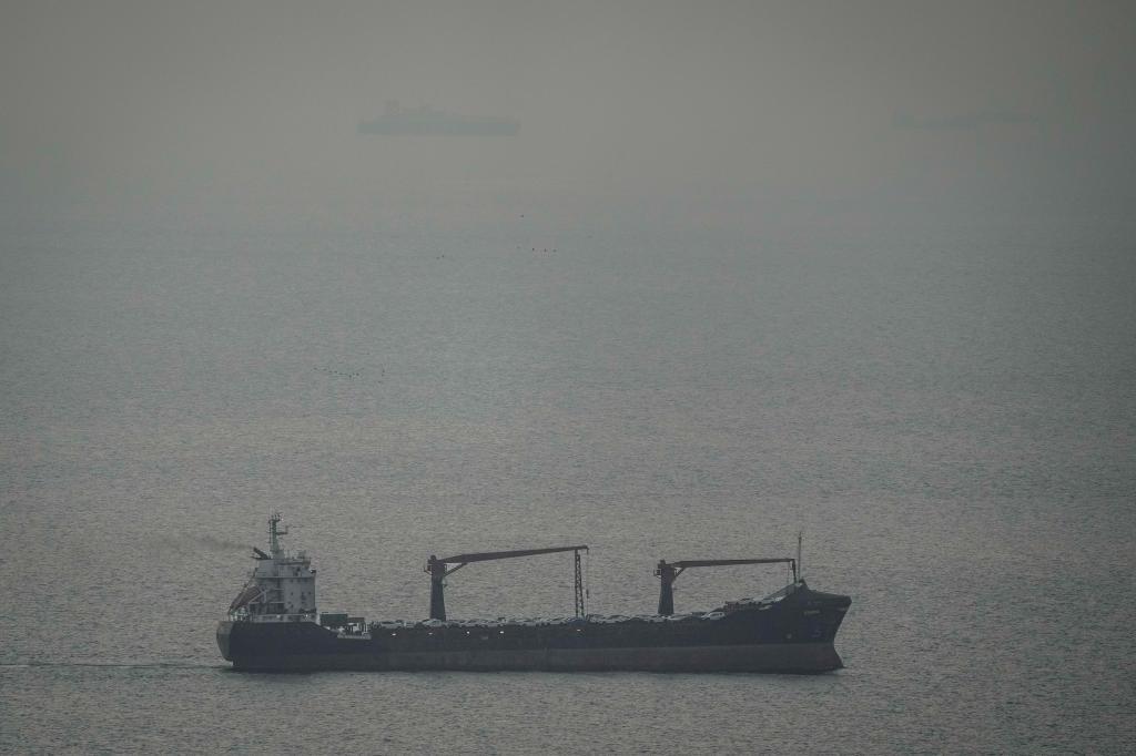 A cargo ship carrying vehicles sails through the Arabian Gulf toward the Strait of Hormuz