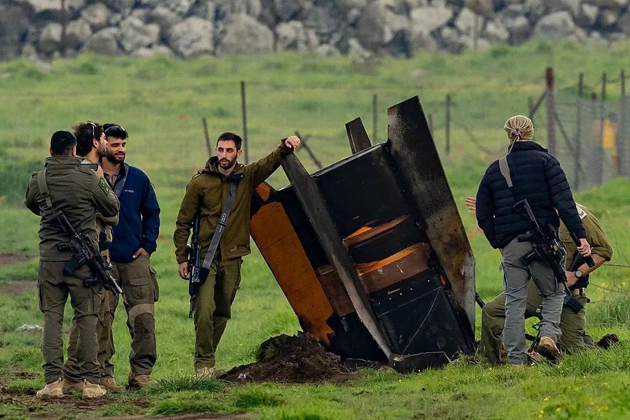 Israeli security personnel secure an area around a partially buried rocket in a field in the Israeli-annexed Golan Heights.