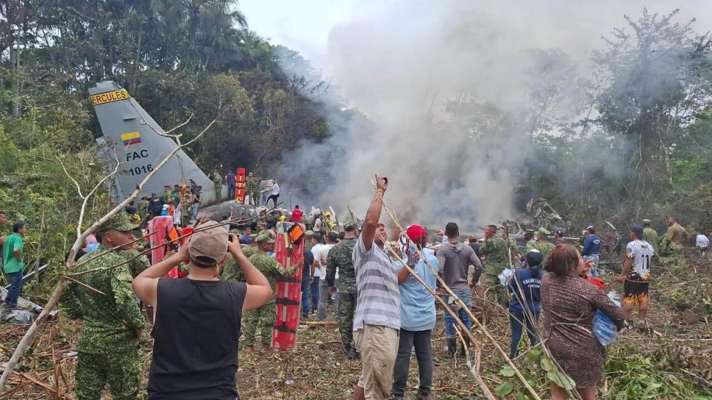 Many people surround a crashed military cargo plane in Colombia.