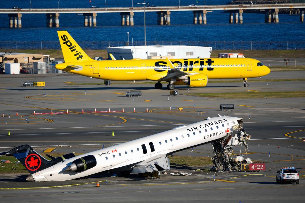 An Air Canada Express jet and Port Authority fire truck lay on the side of a runway at LaGuardia Airport,