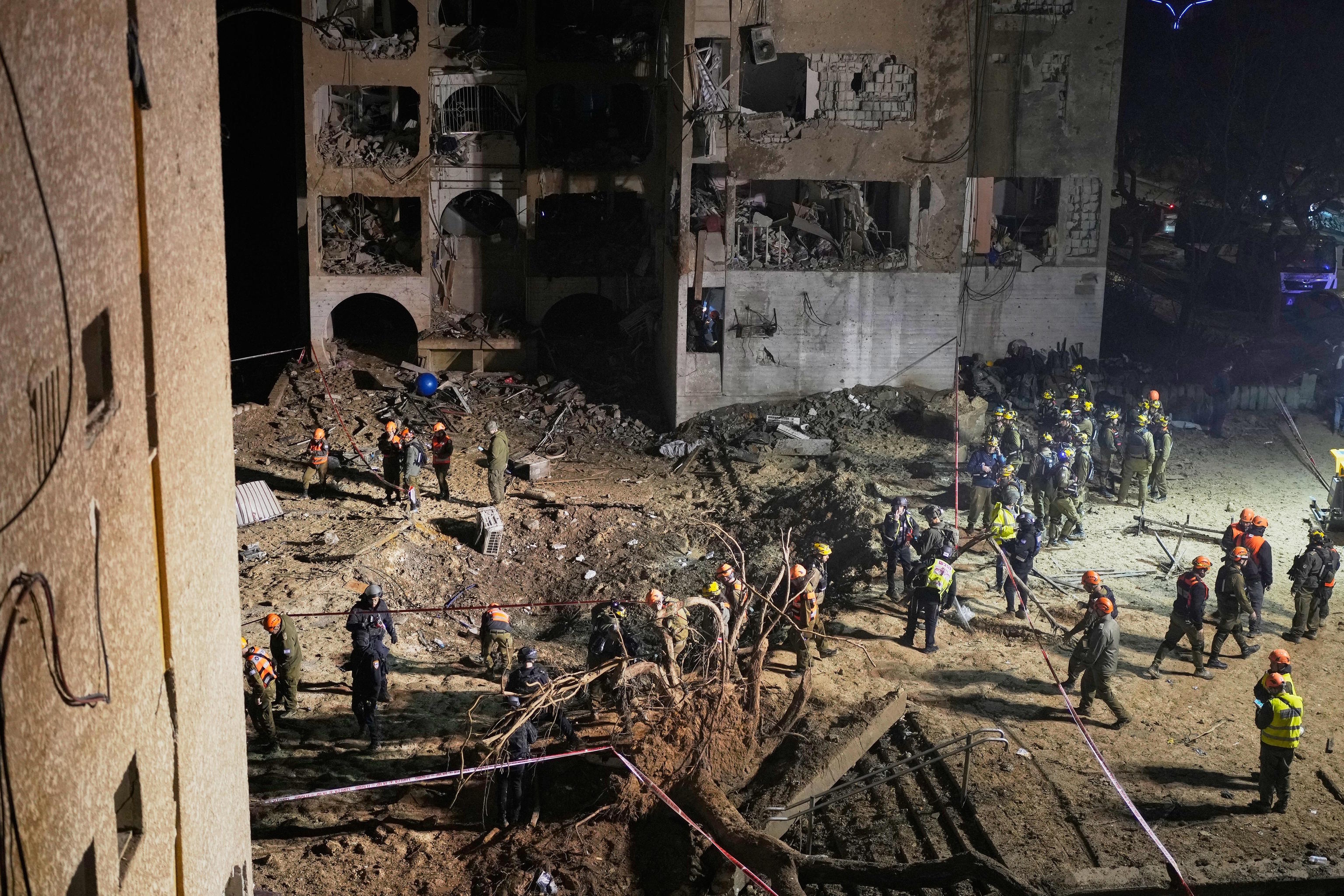 Israeli security forces and rescue teams work at the site struck by an Iranian missile.