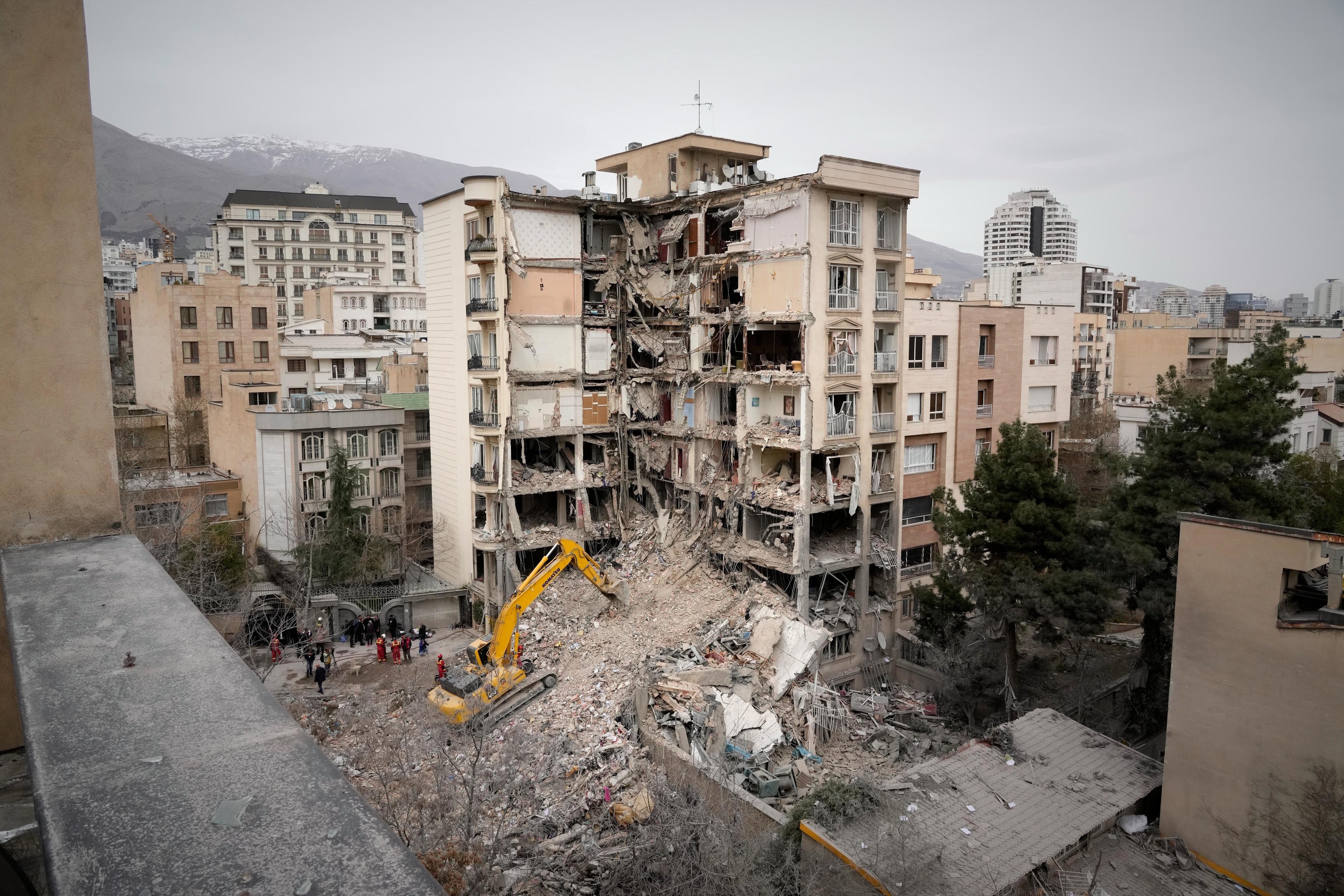 Iranian emergency workers clear rubble from a residential building that was hit in an U.S.-Israeli strike in Tehran.