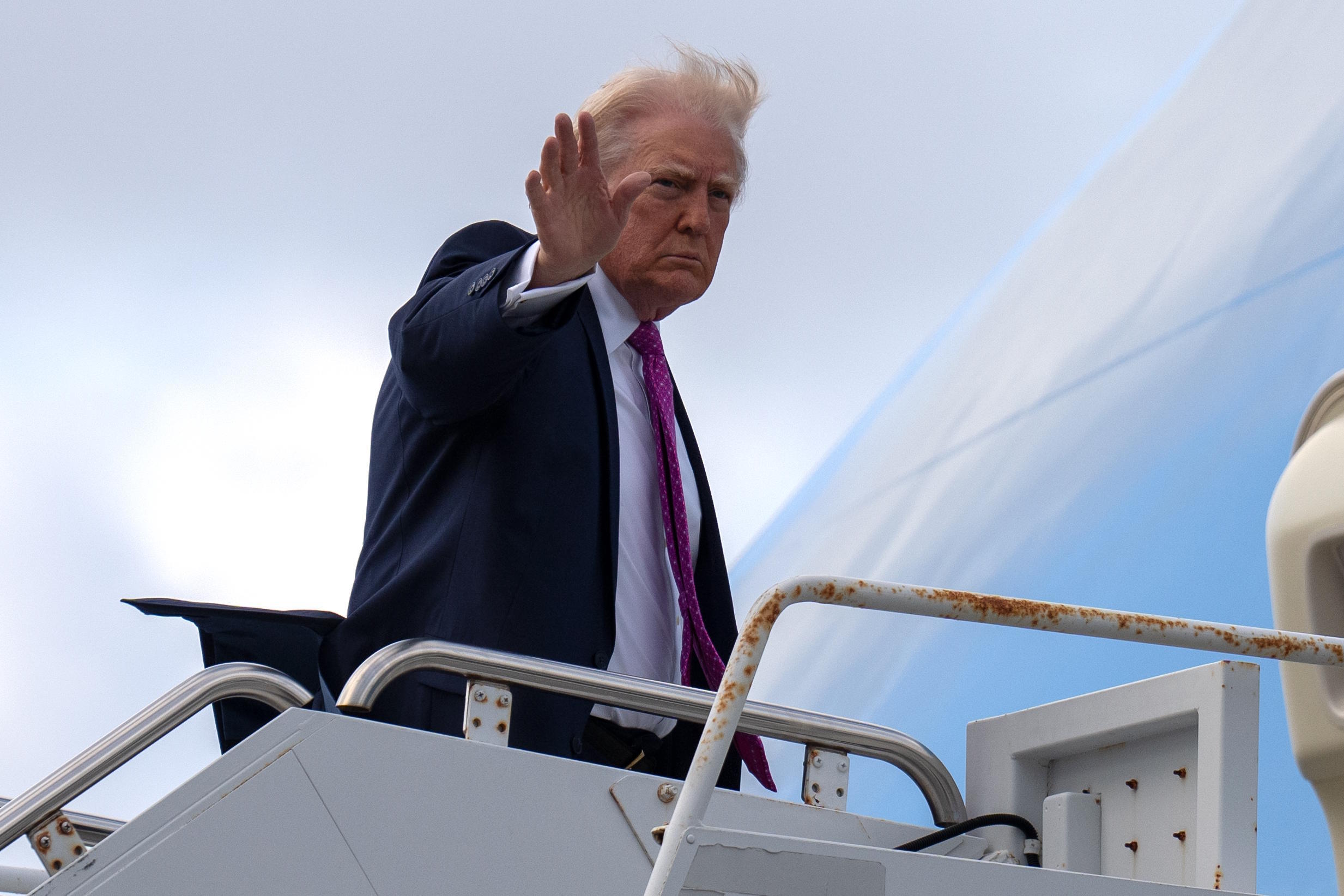 President Donald Trump waves as he boards Air Force One.
