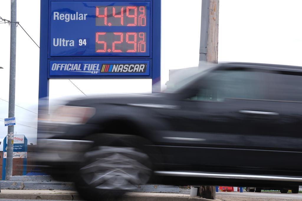 A vehicle drives past a sign displaying fuel prices at a gas station in Philadelphia.