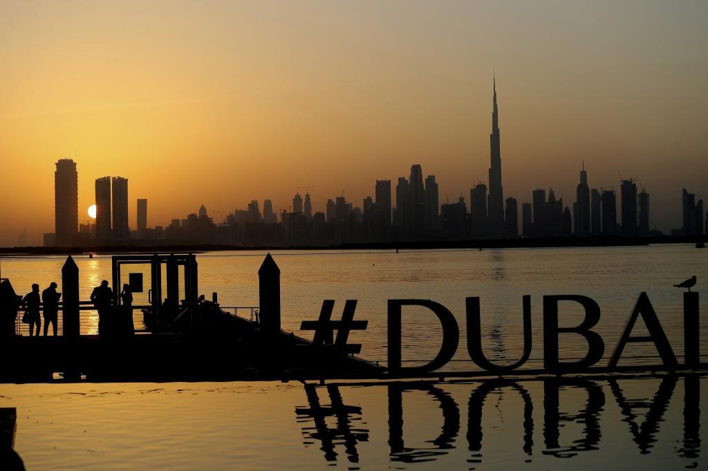 People enjoy the sunset with the view of city skyline and the world tallest tower, Burj Khalifa, in Dubai