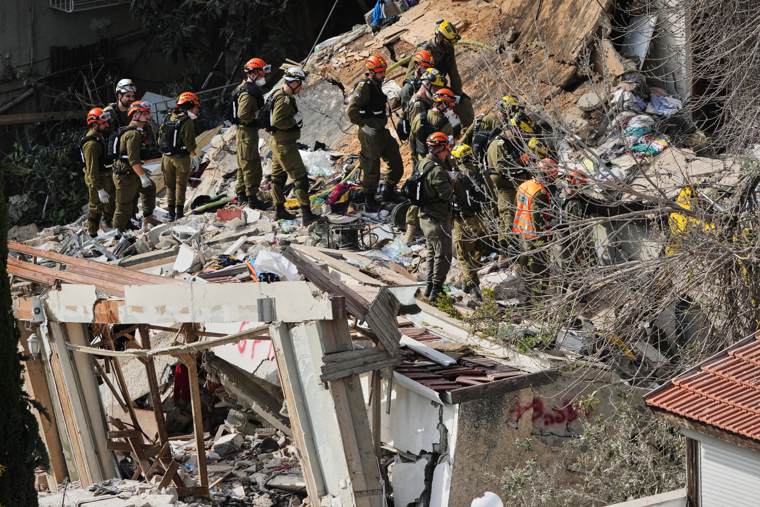 Israeli rescue teams search for missing people in the rubble of a building in Haifa.