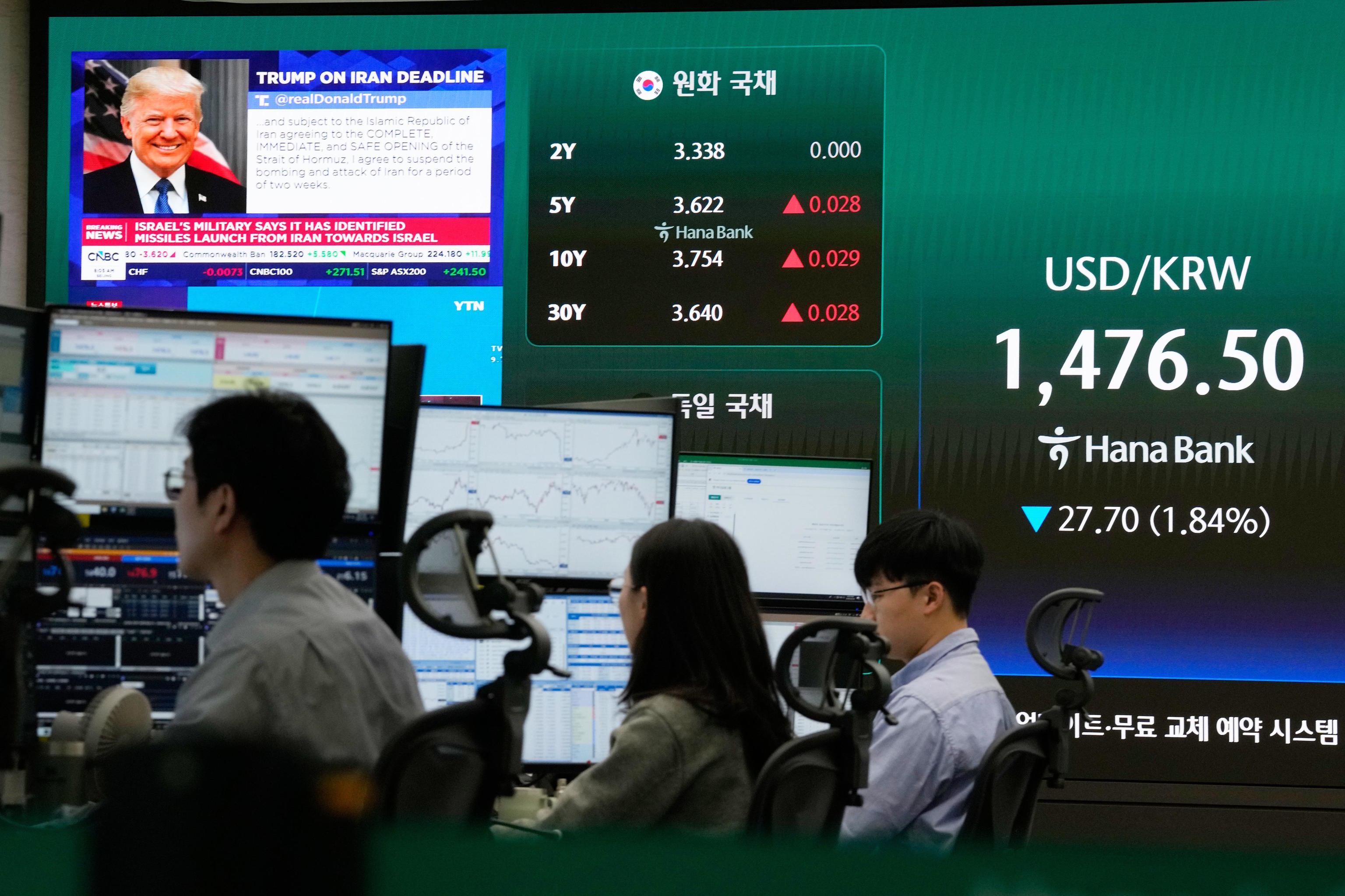 U.S. President Donald Trump is seen on a screen as traders work at the foreign exchange dealing room of the Hana Bank headquarters in Seoul.