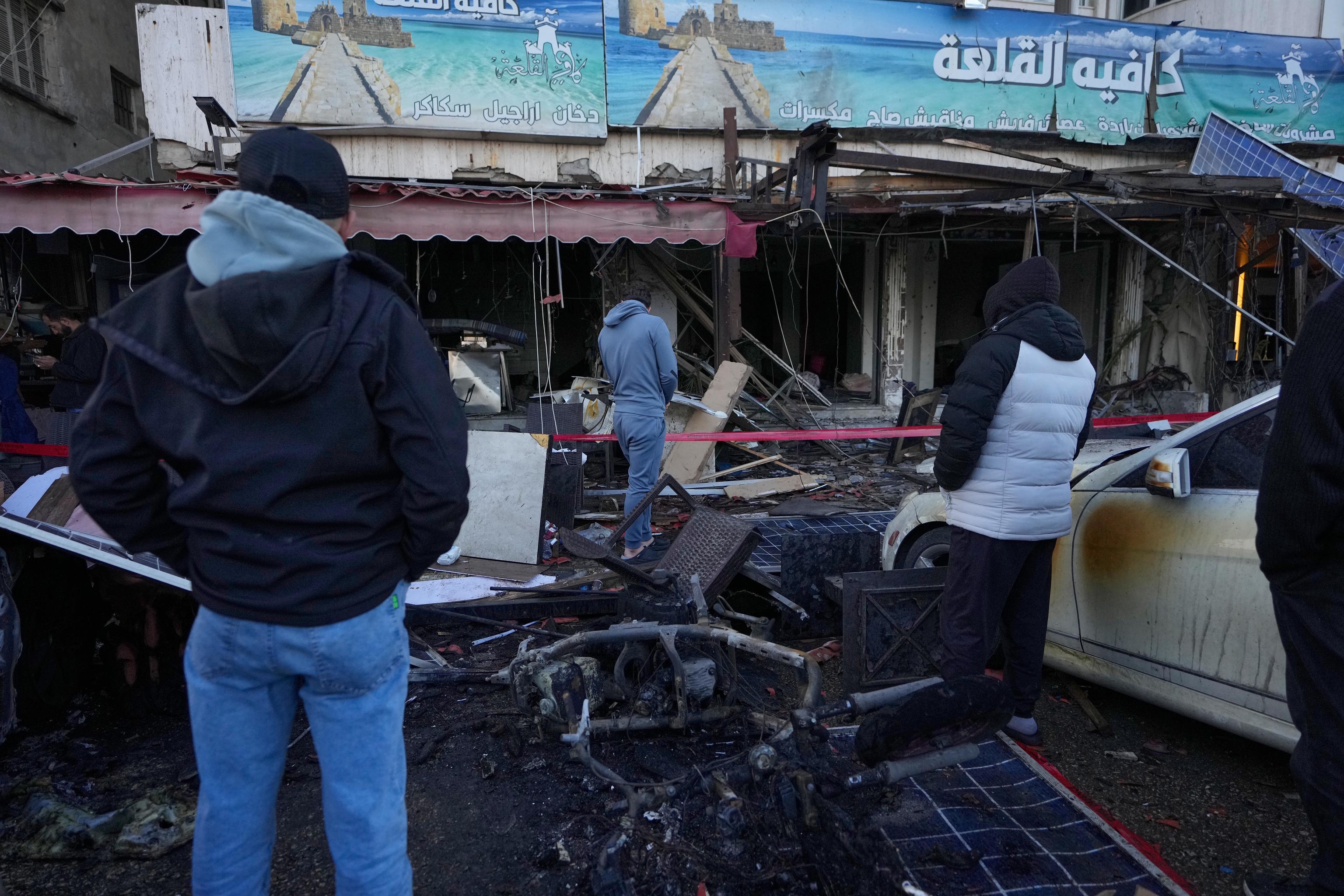 People check a destroyed coffeeshop of an Israeli strike in Sidon, Lebanon.