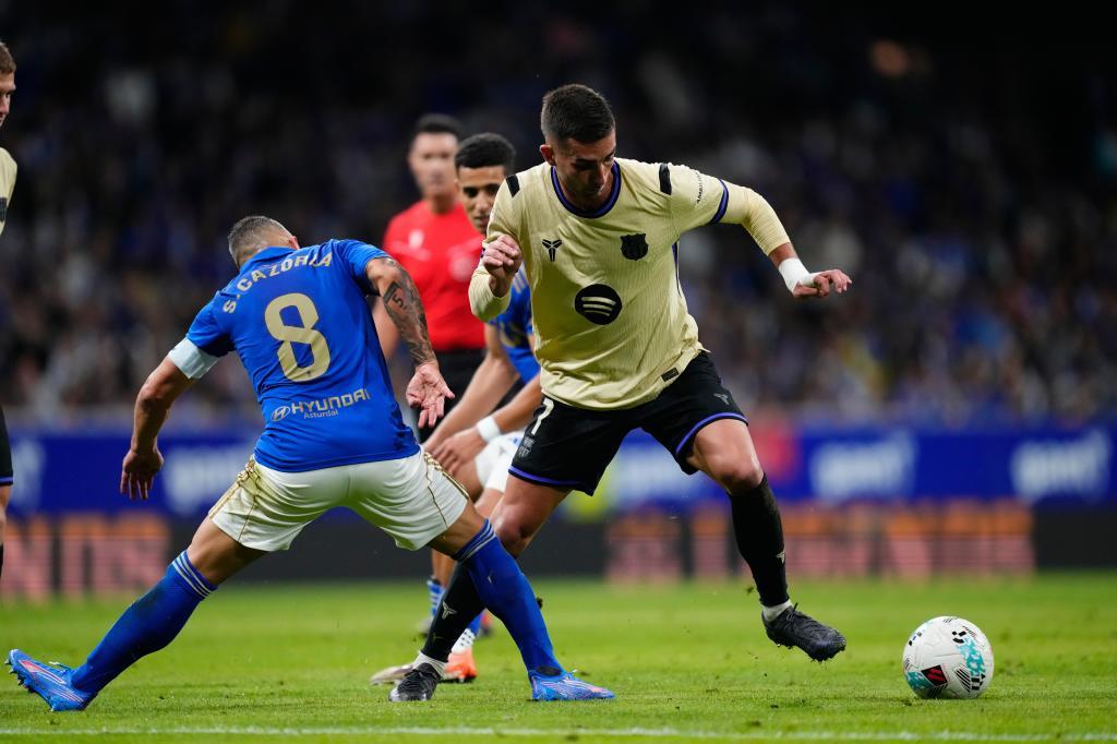 Barcelona's Ferran Torres fights for the ball against Real Oviedo's Santi Cazorla