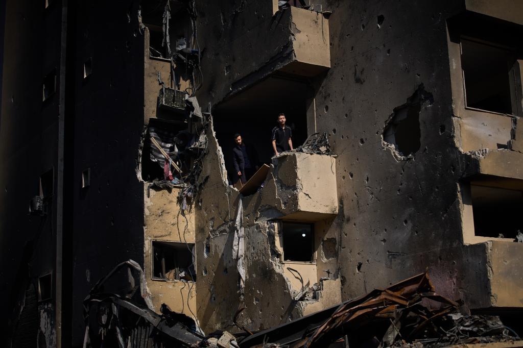 Men inspect the damage to their home destroyed in an Israeli airstrike a day earlier in Beirut