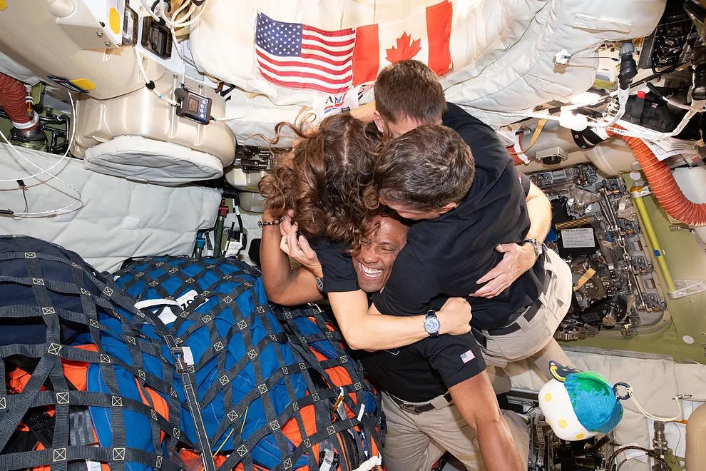 Artemis 2 astronauts embracing during their return to Earth.
