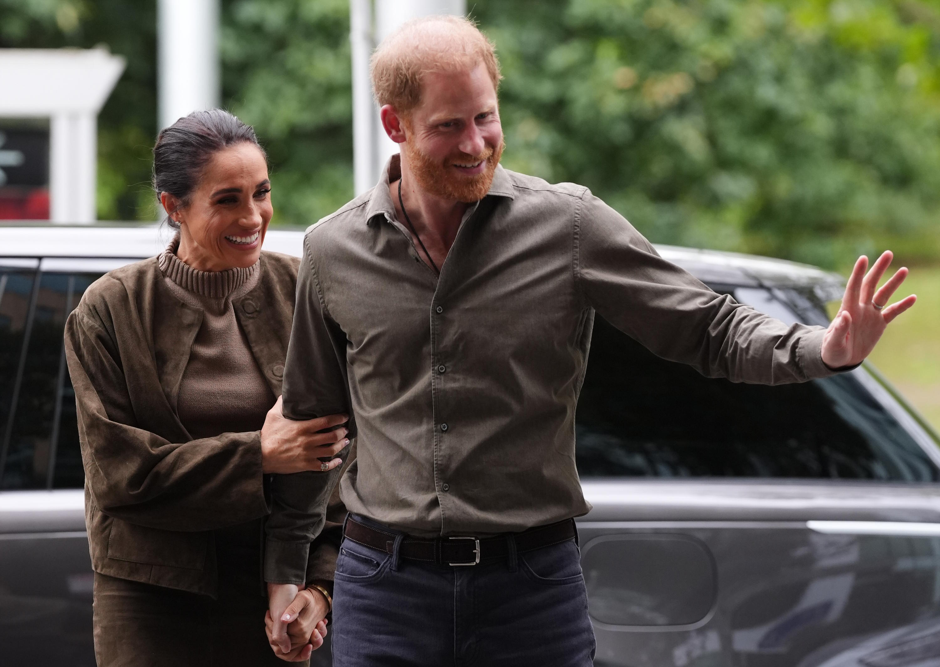 Prince Harry, right, and Meghan Markle, left, the Duke and Duchess of Sussex, arrive at the Australian National Veterans Arts Museum.