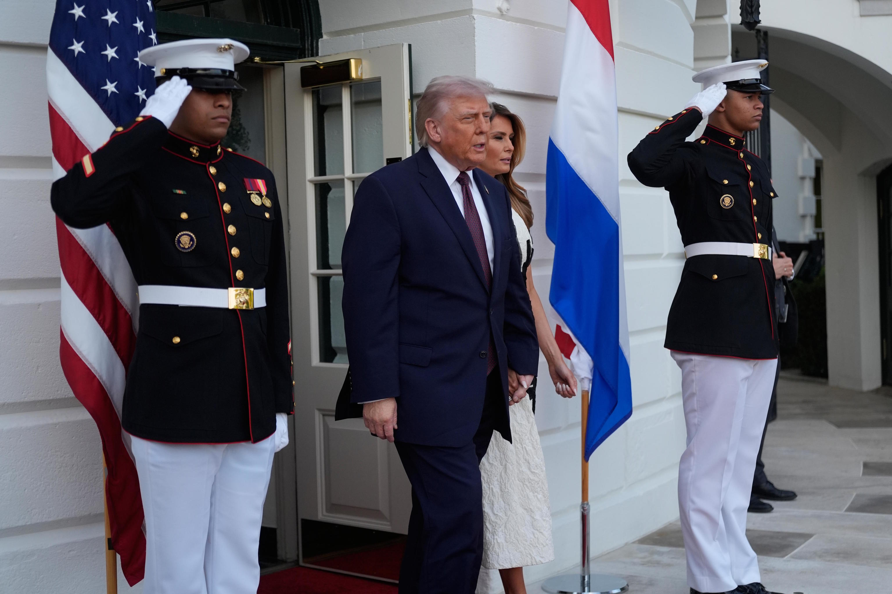 President Trump and first lady Melania Trump walk from the White House.