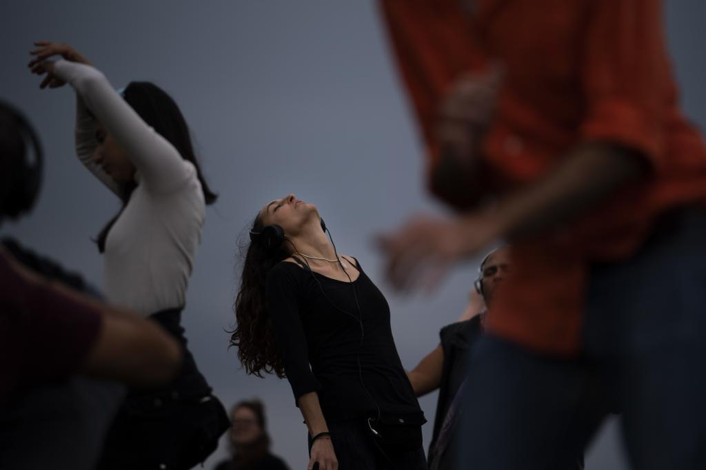 People dance as they take part in a Silent Disco session in front of the sea in Barcelona