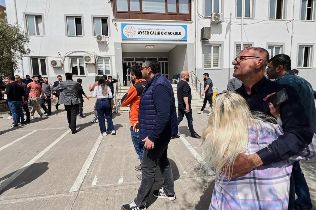 People stand at the courtyard of a secondary school where an assailant opened fire