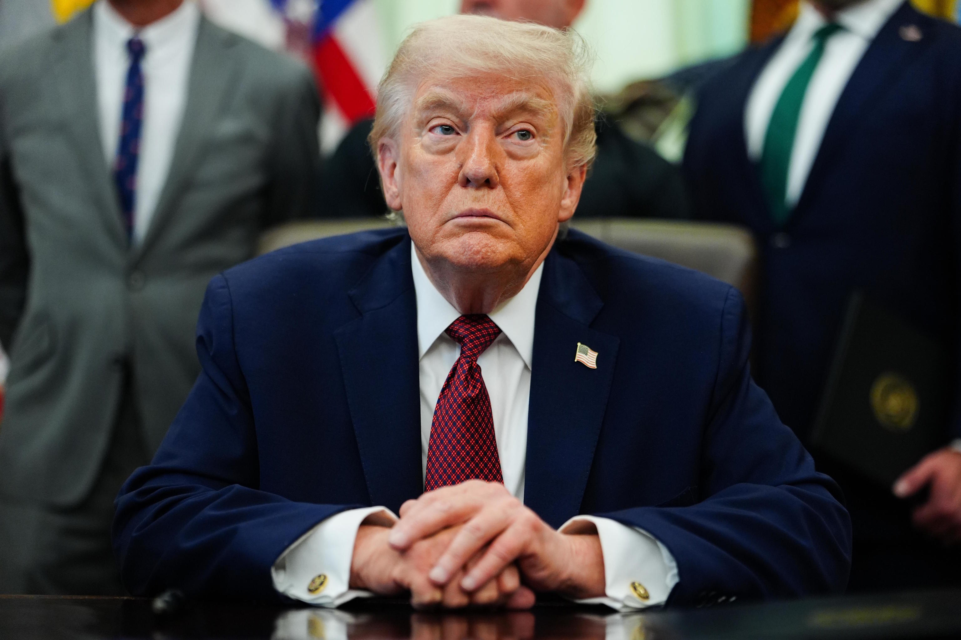 President Donald Trump listens in the Oval Office of the White House.